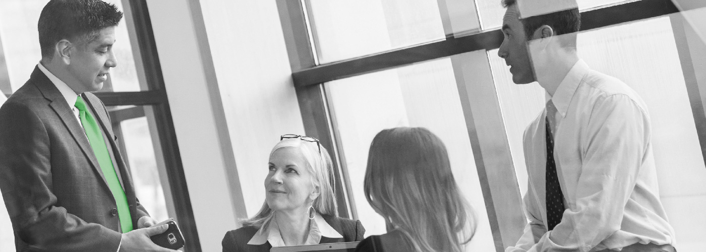 decorative image of four people working around a table