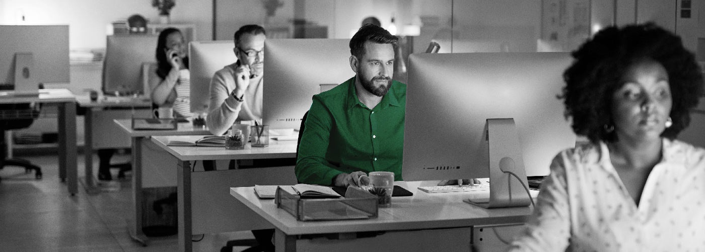 Decorative image: fow of desks with people working at computers