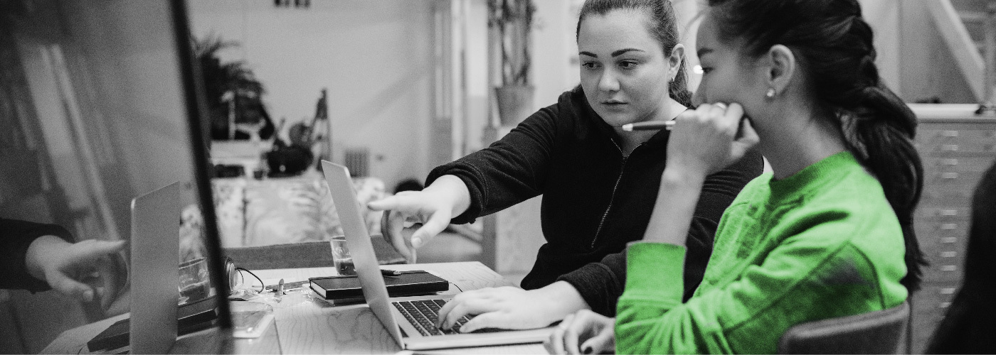 Decorative image of two people working on a laptop