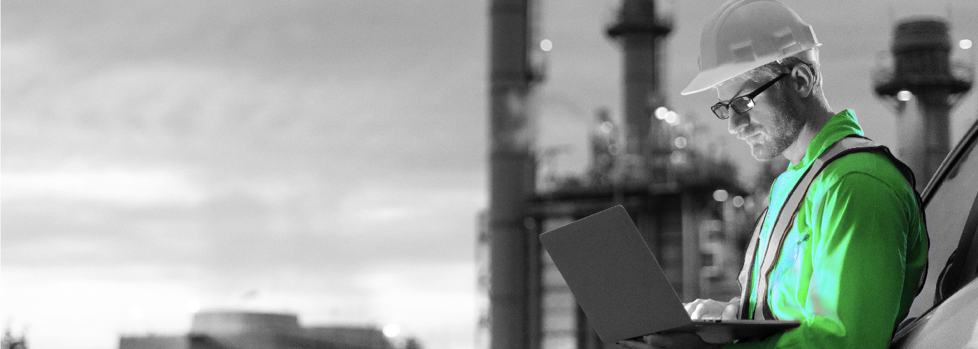 Decorative image: Worker in a heard hat consulting a laptop