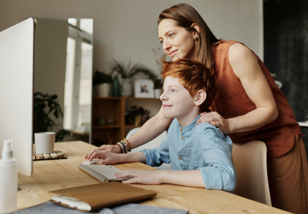 Parent helping child on computer