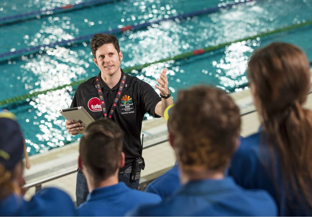 Male teaching at pool with a Tafe t-shirt
