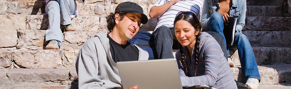 man and woman on laptop outside