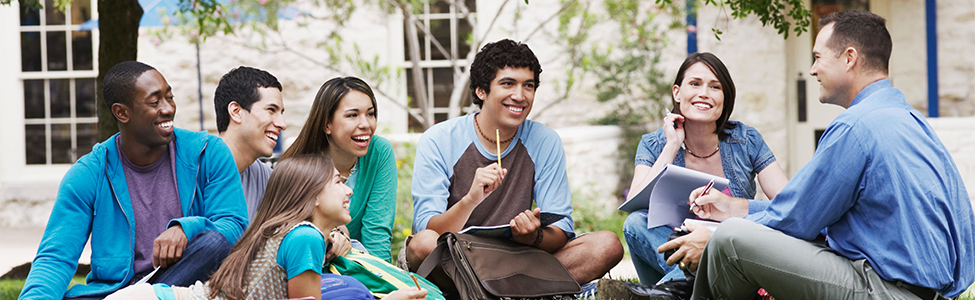 teacher teaching students outside on grass