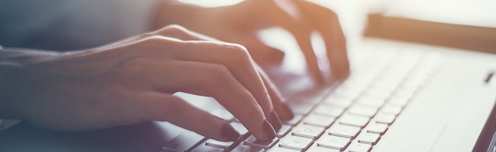 hands typing on computer